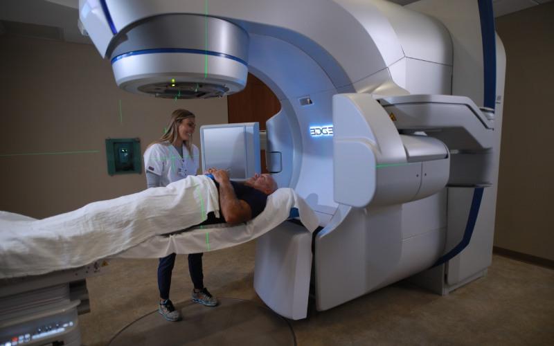 Radiation Therapist observes patient laying in mri scan machine